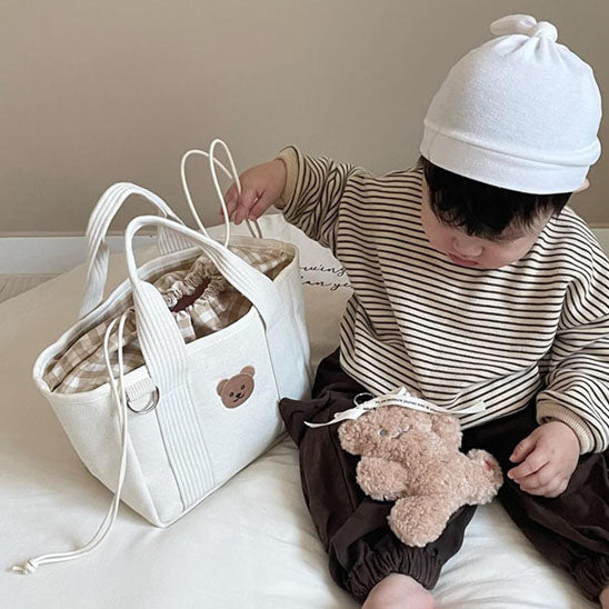 bebe assis tient sac langer
